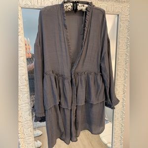 This charcoal tunic opens in front for a casual look. Dainty ruffle are cute!